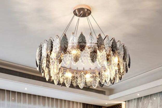 Luxurious living room with a crystal chandelier, sofa, and entertainment system.